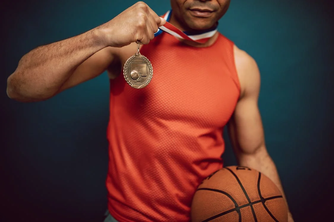 Athlete holding a basketball and a medal, symbolizing mental strength and competitive success